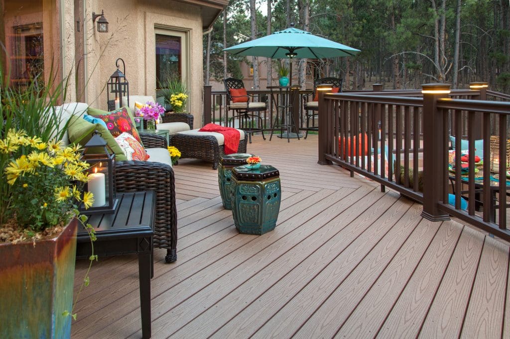 Beautiful backyard deck with built-in lighting and fully decorated with vibrant and colorful furniture and decor